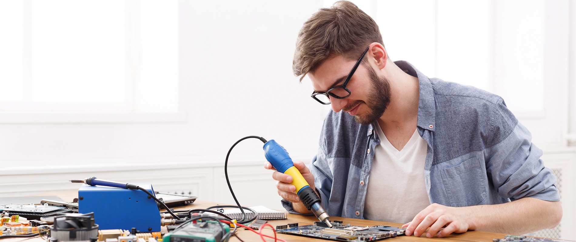 Technician repairing motherboard by air dryer تعمیر تلویزیون در اصفهان